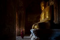 Biddende monnik bij Boeddha
